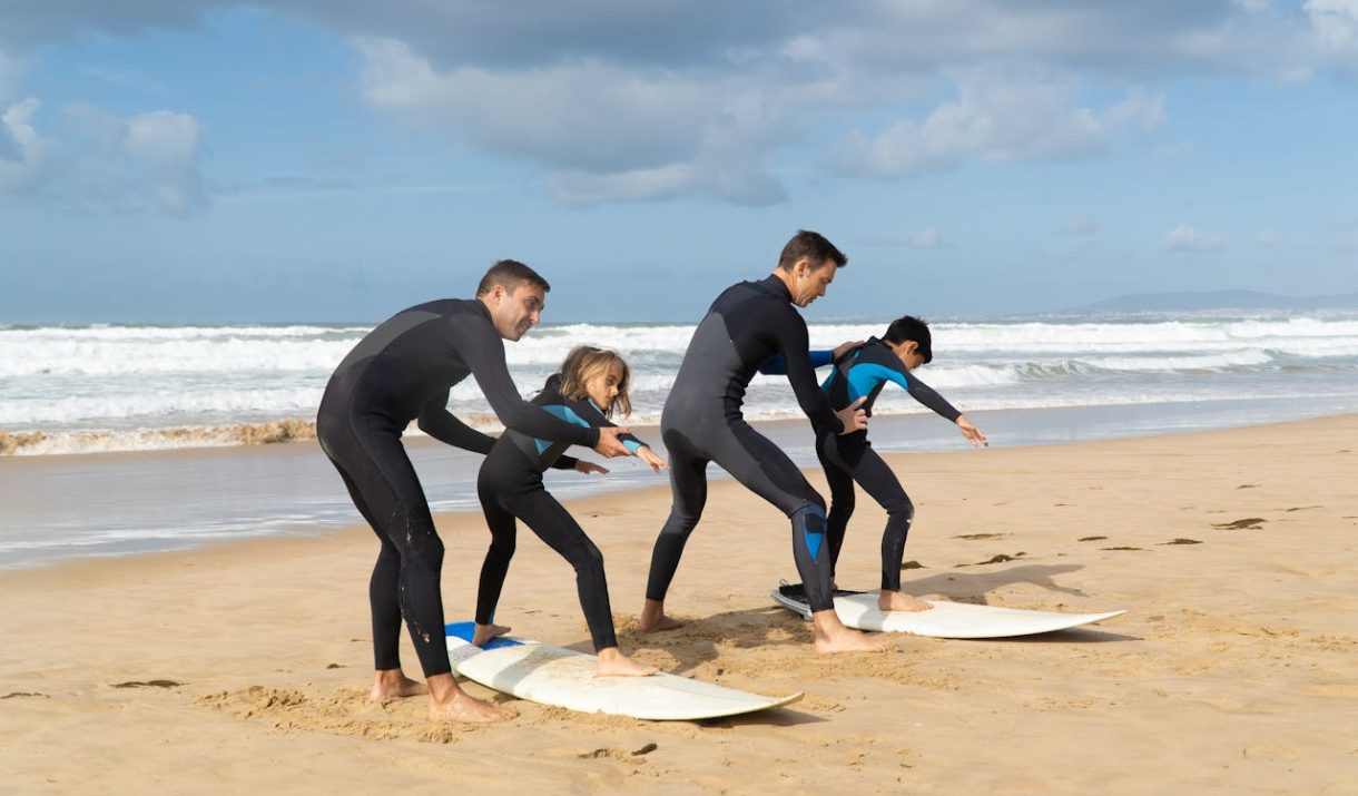Group learning to surf on a sunny beach in Portugal. Perfect for lifestyle and travel themes.