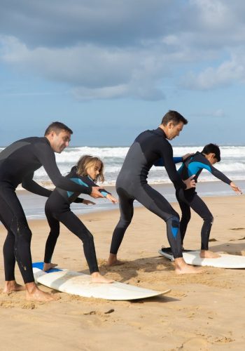 Group learning to surf on a sunny beach in Portugal. Perfect for lifestyle and travel themes.